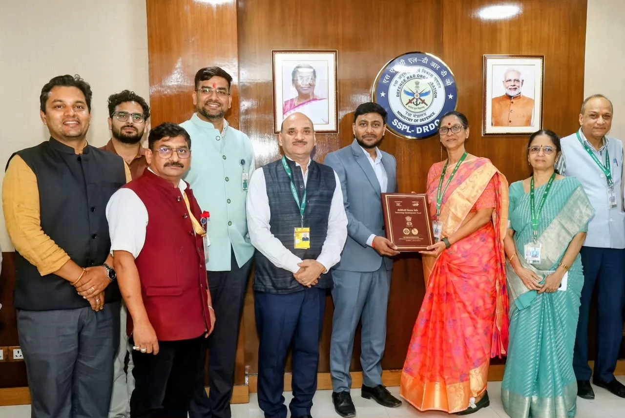 Nine people, DRDO officials and Zero mK India representatives, stand in a row in front of a wood-panelled wall carrying the SSPL-DRDO emblem, as two of them hold up a maroon Technology Development Fund agreement folder
