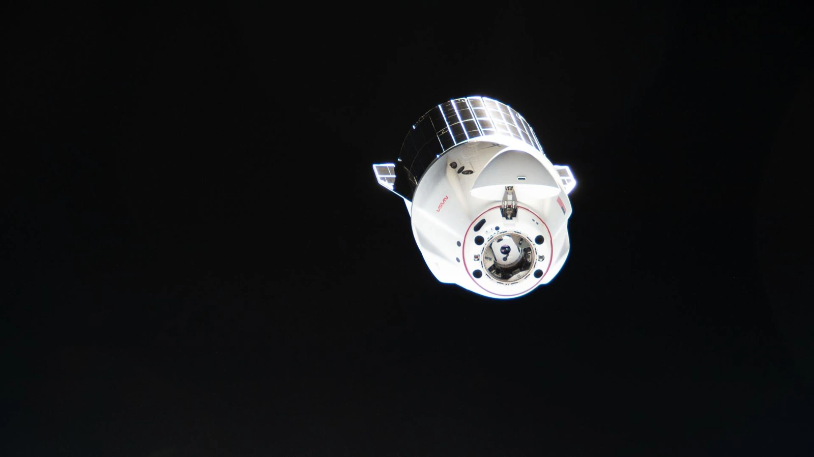 A Cargo Dragon spacecraft viewed from the International Space Station as it departs into space.