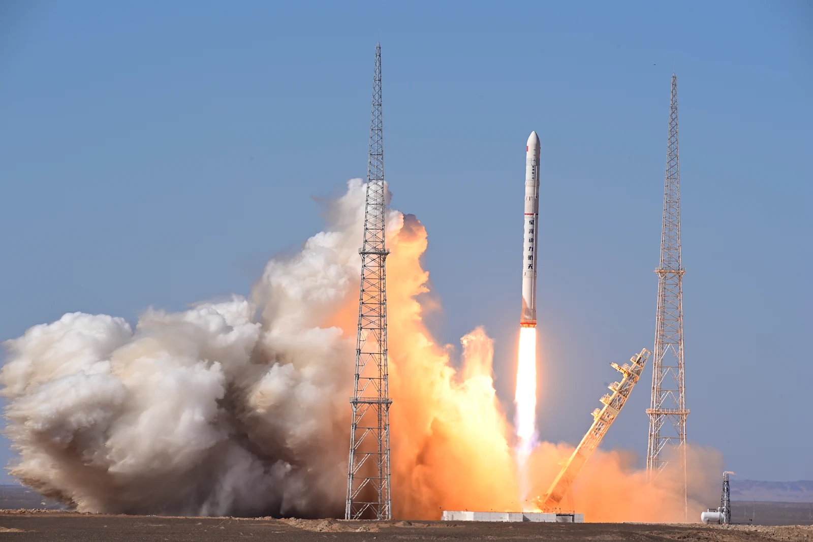 Pallas-1 lifting off between launch towers.