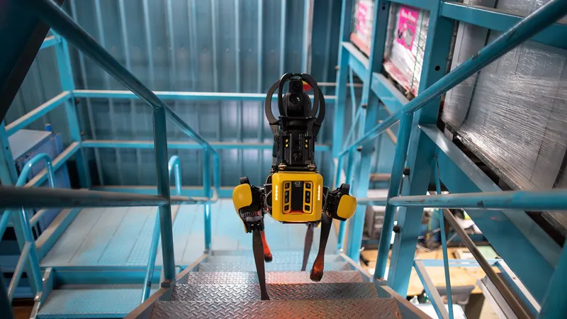 A Boston Dynamics Spot quadruped climbing an industrial staircase