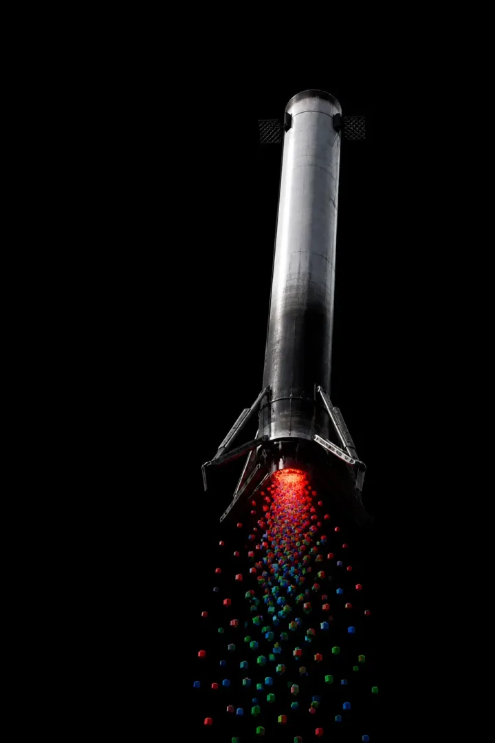 Concept artwork of a lone sooty booster tilted against black space, legs beginning to deploy, cubes falling from its base.